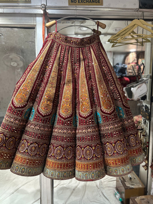 Lehenga nupcial de color granate con un pesado diseño de baile